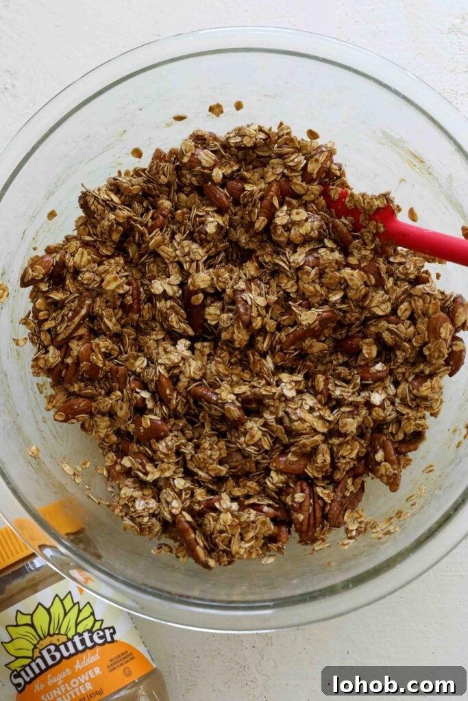SunButter Gingerbread Granola in a bowl with a spatula by Flora & Vino