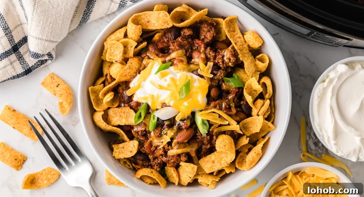 Overhead image of slow cooker frito pie with garnish.