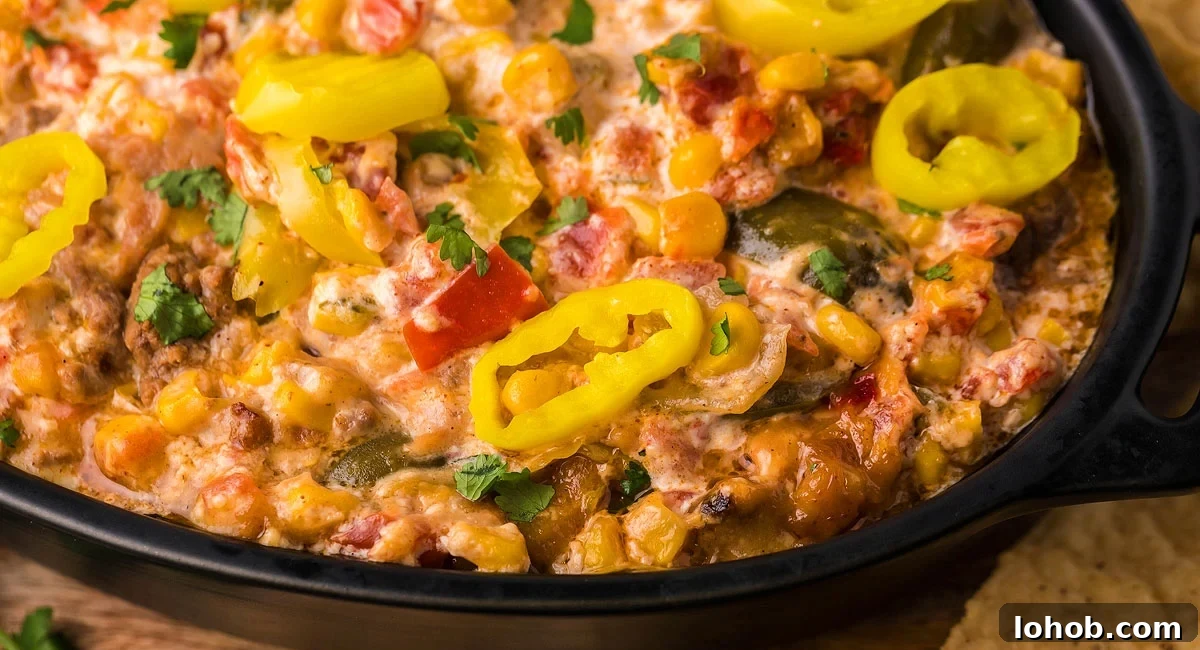 Overhead image of loaded slow cooker taco dip with garnish.