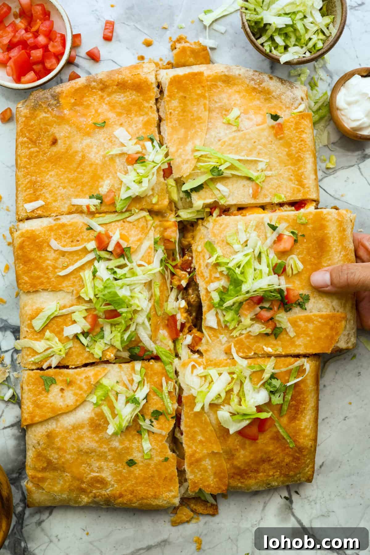 Overhead shot of crunchwrap casserole topped with shredded lettuce, tomatoes and cilantro.