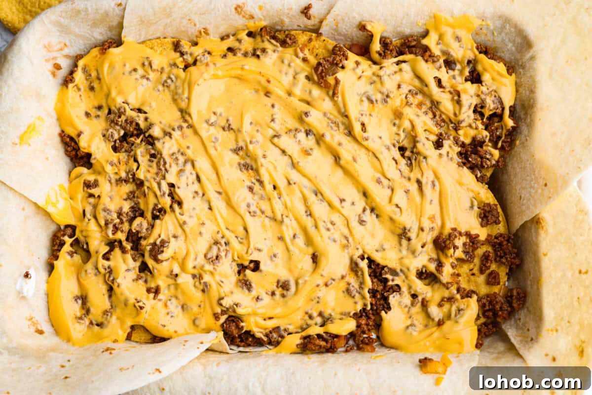 Nacho cheese layered and spread out over the top of the ground beef.