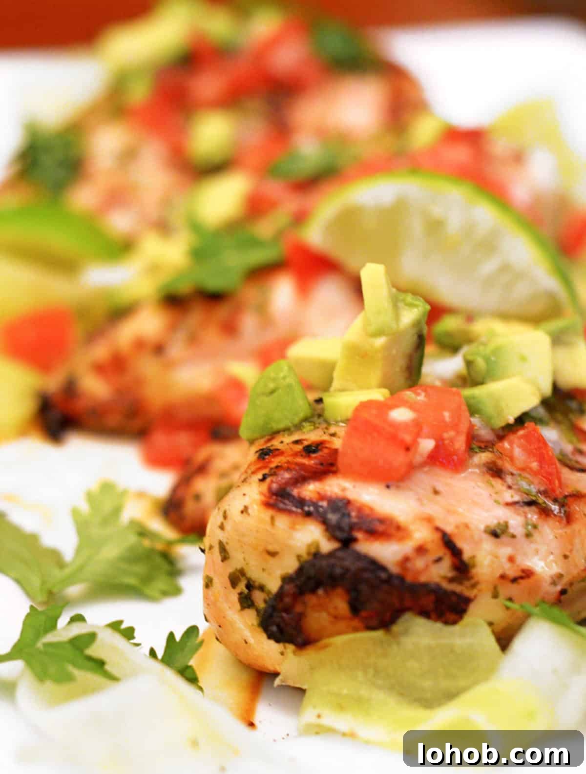 Grilled Chicken with Fresh Avocado Salsa Recipe 2 A platter of grilled chicken with lime, diced tomatoes, and avocado salsa.