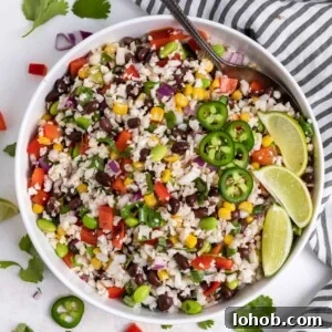 Black Bean & Cauliflower Rice Salad with Lime and Cilantro 7 White salad bowl with cauliflower rice salad with serving spoon.