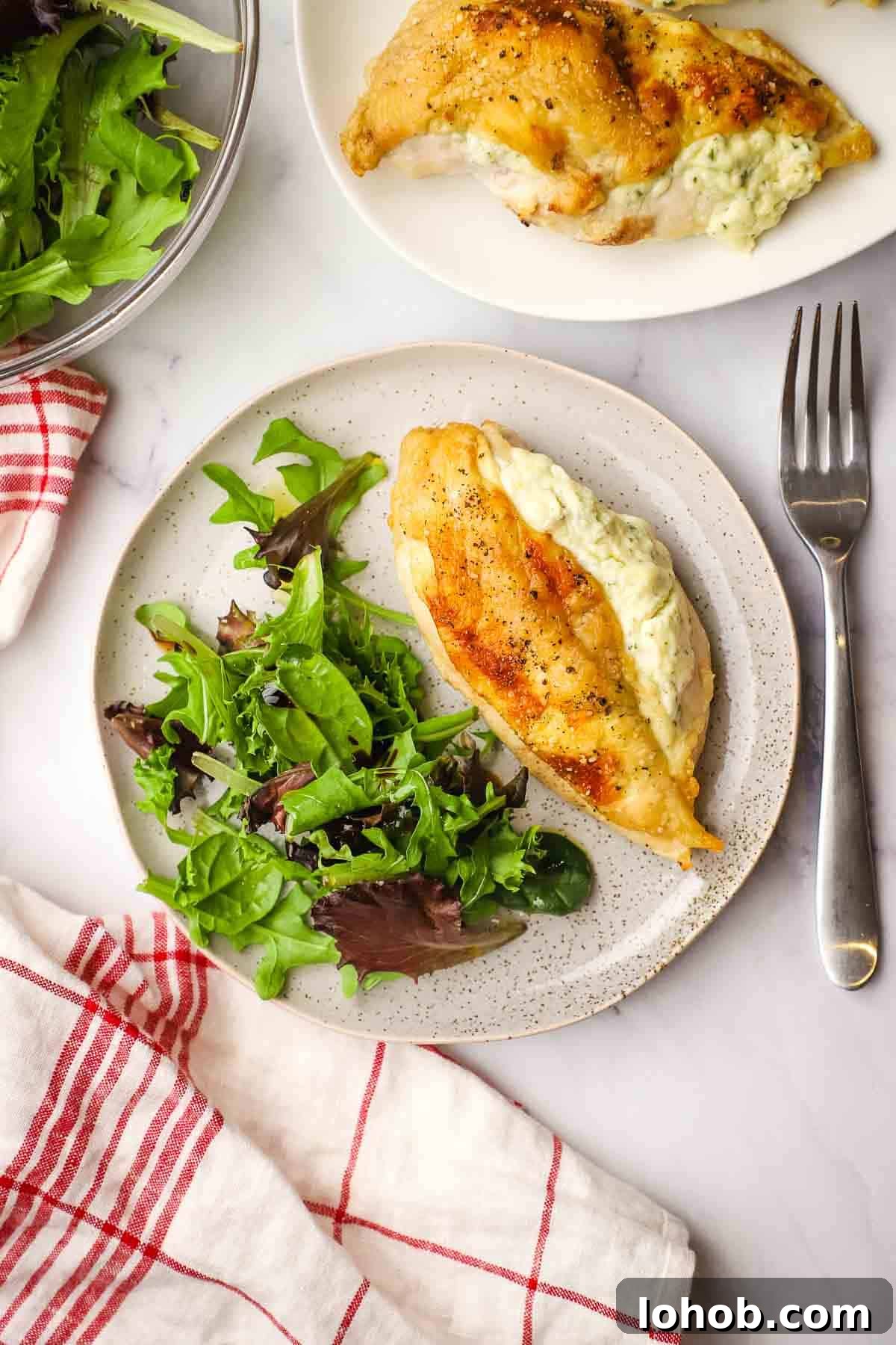 Creamy Boursin-Stuffed Chicken Breast Recipe 11 A plate of Boursin stuffed chicken and spring mix salad.