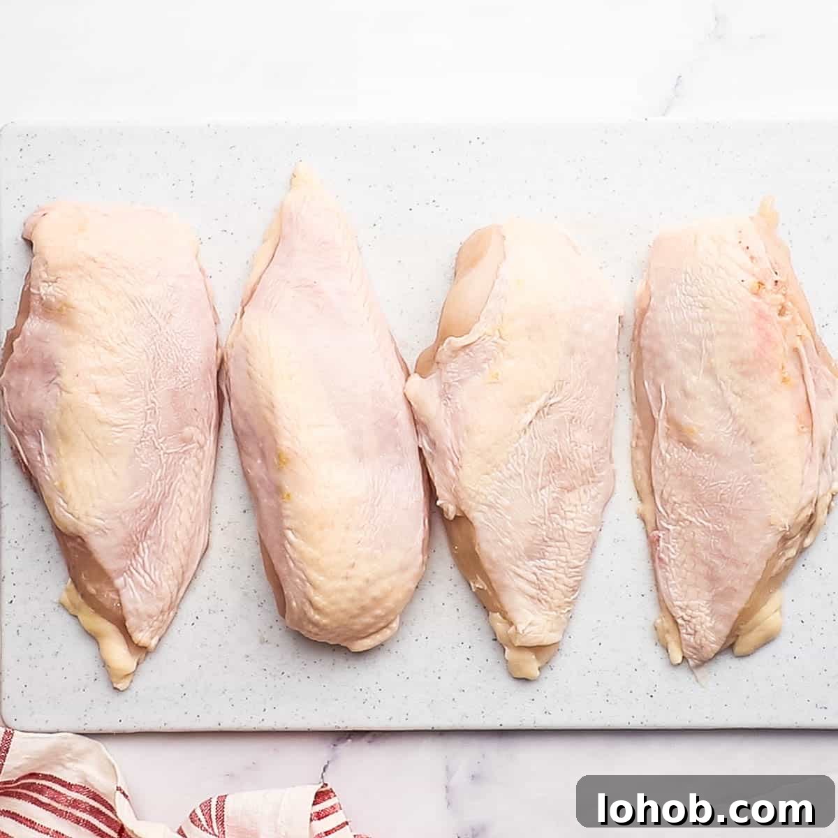 Creamy Boursin-Stuffed Chicken Breast Recipe 6 an overhead picture of 4 chicken breasts on a cutting board