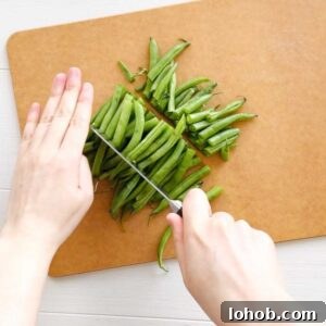 Wash green beans. Trim woody ends and cut green beans into thirds.