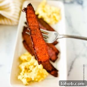 White platter with turkey bacon and scrambled eggs.