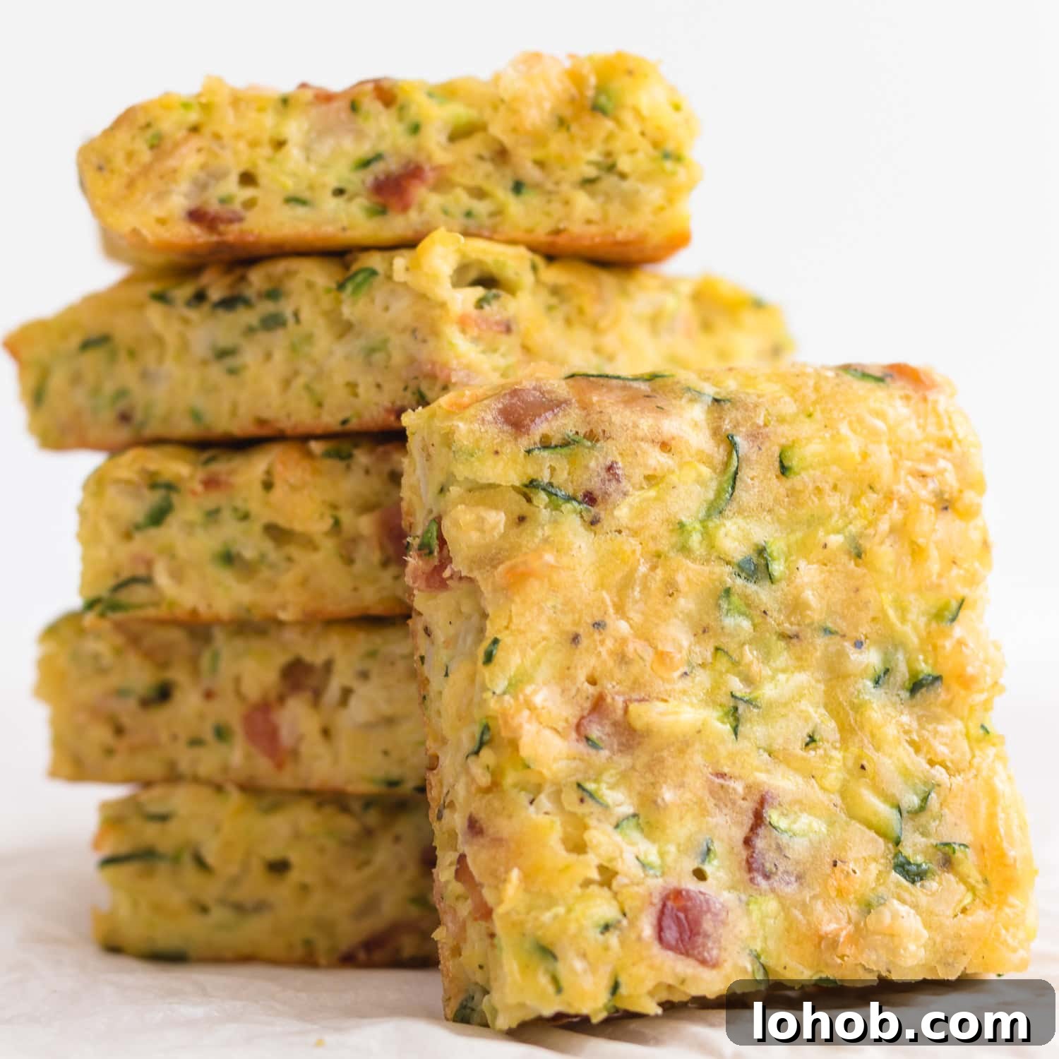 Pile of zucchini slice with one piece leaning against it.