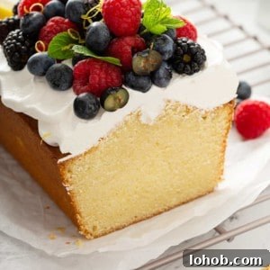 Cross view of sliced lemon whipping cream cake, topped with whipped cream and berries