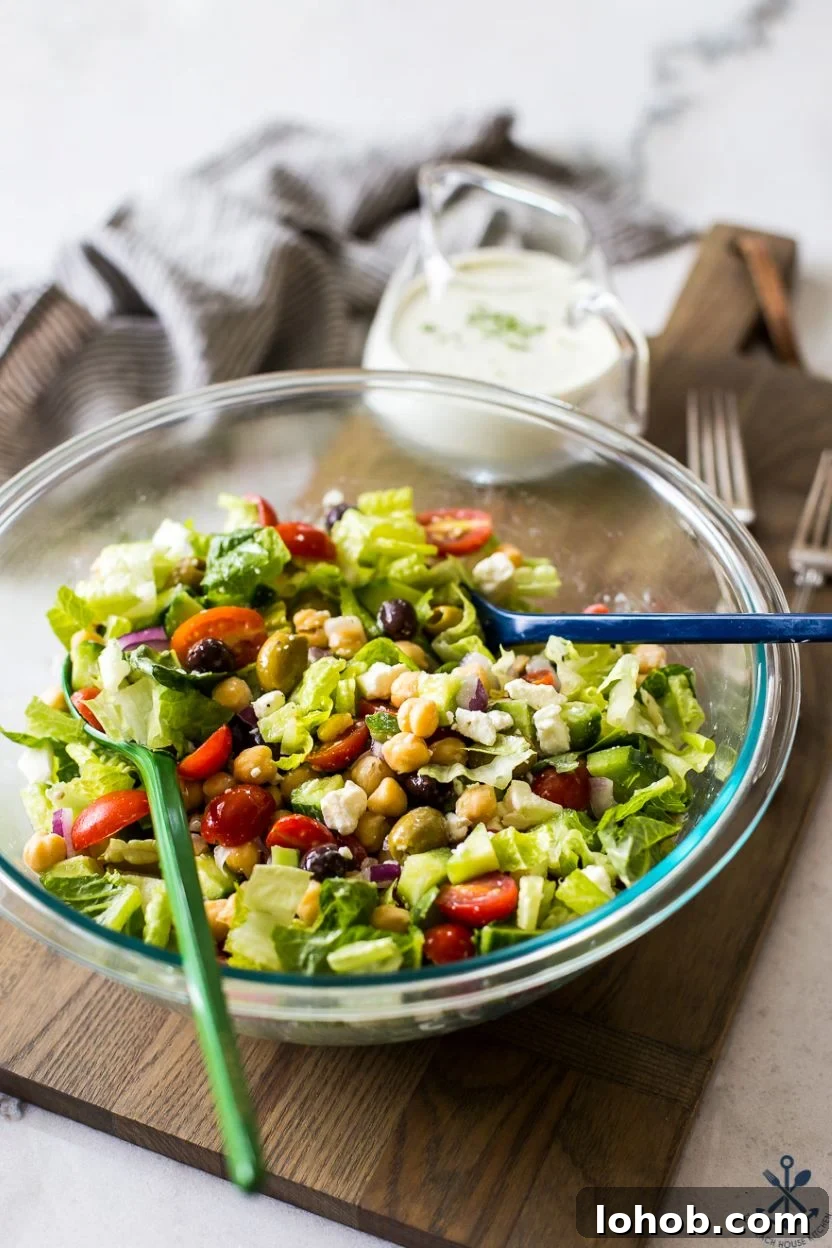 Greek Chickpea Salad with Creamy Green Goddess Dressing 6 A Greek Chickpea Salad with Green Goddess Dressing in a glass bowl