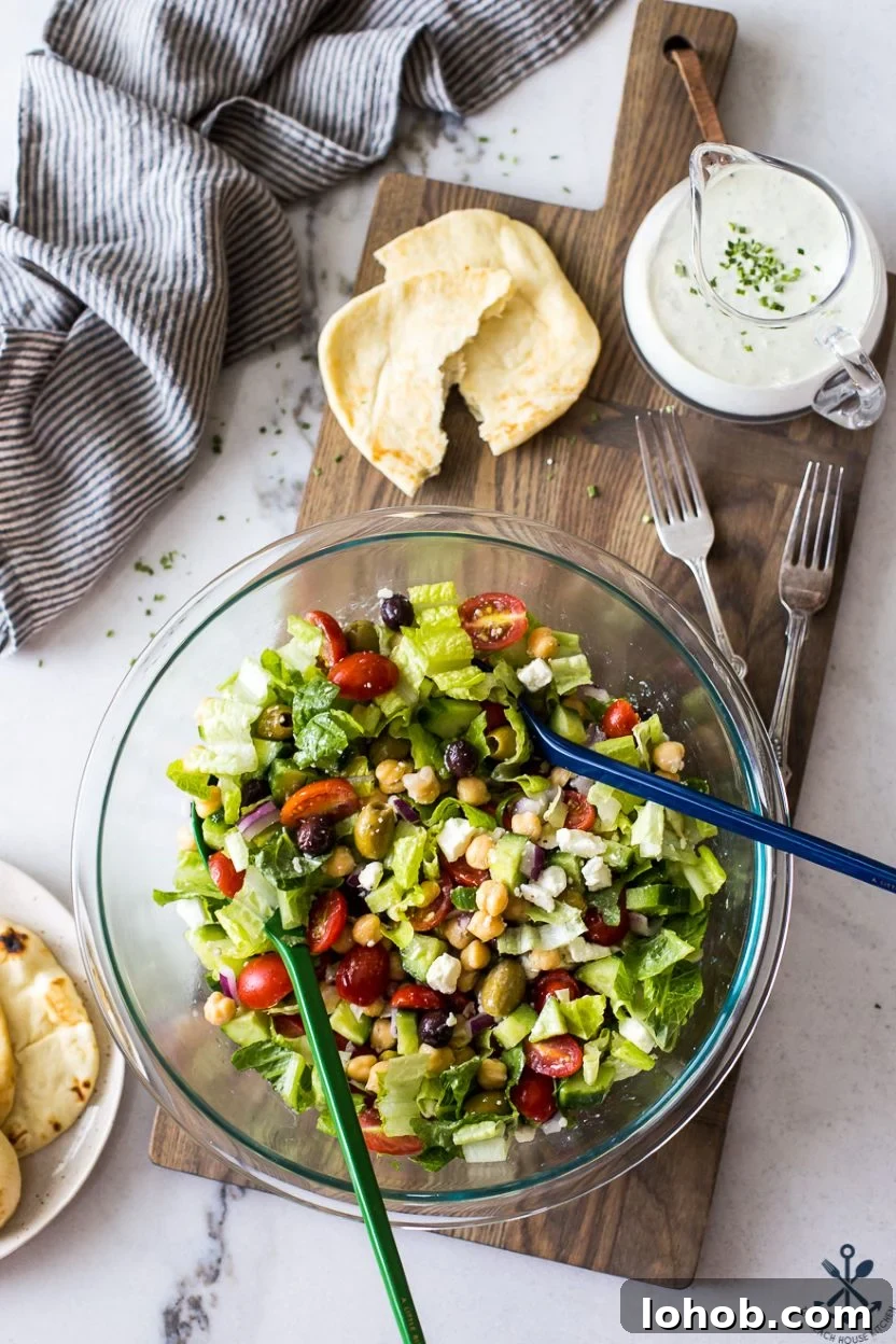 Greek Chickpea Salad with Creamy Green Goddess Dressing 7 Overhead photo of a Greek Chickpea Salad with Green Goddess Dressing in a glass bowl