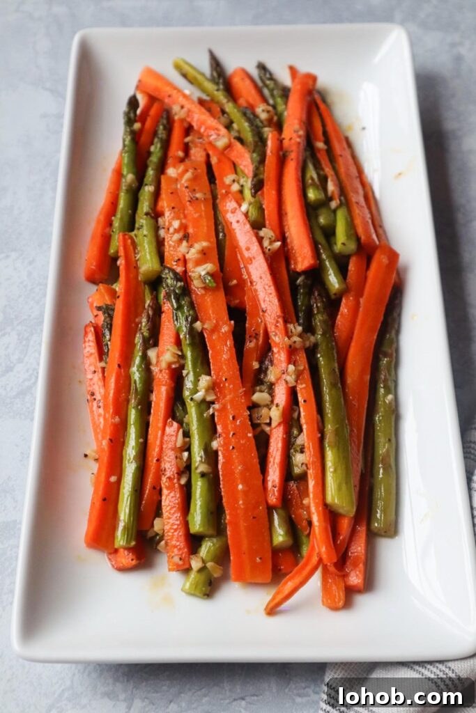 white plate with roasted carrots and asparagus
