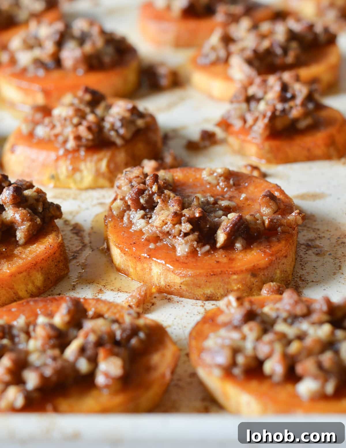 Roasted Sweet Potato Slices with Maple Candied Pecans 11 roasted sweet potato sliced with candied pecans on top.