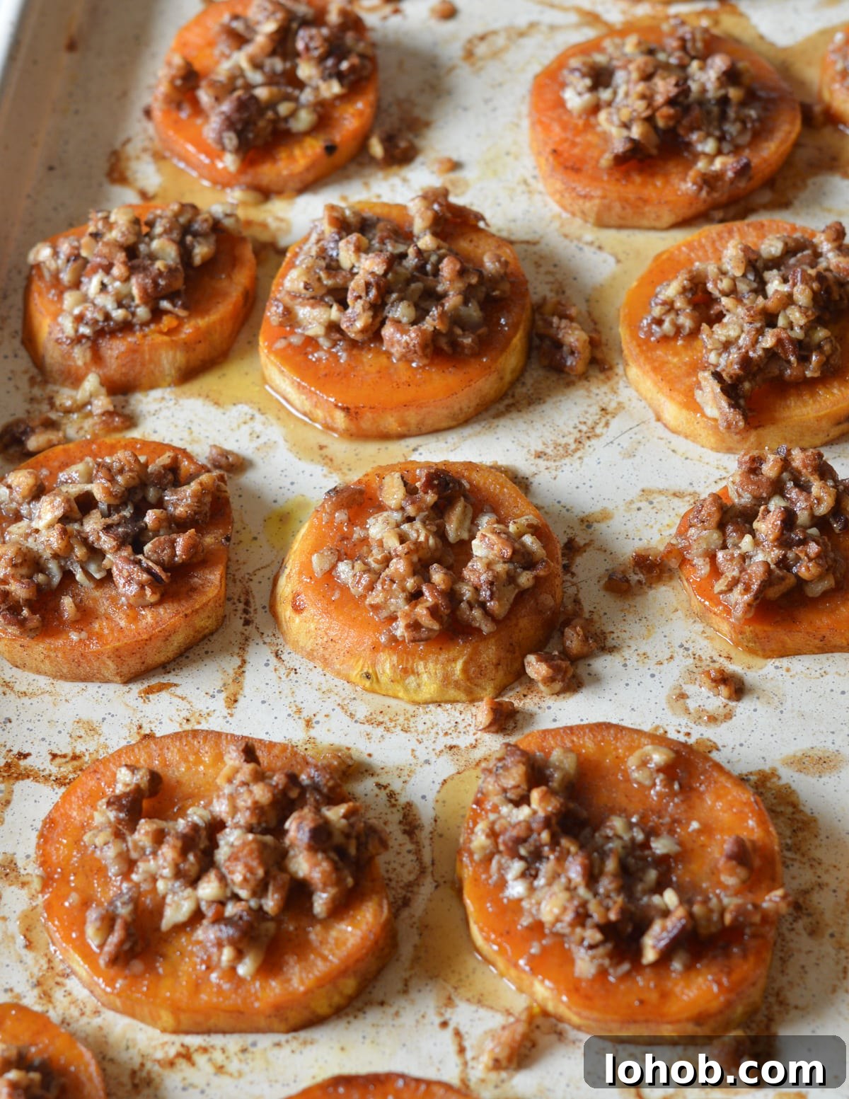Roasted Sweet Potato Slices with Maple Candied Pecans 4 roasted sweet potato slices with candied pecans on top.
