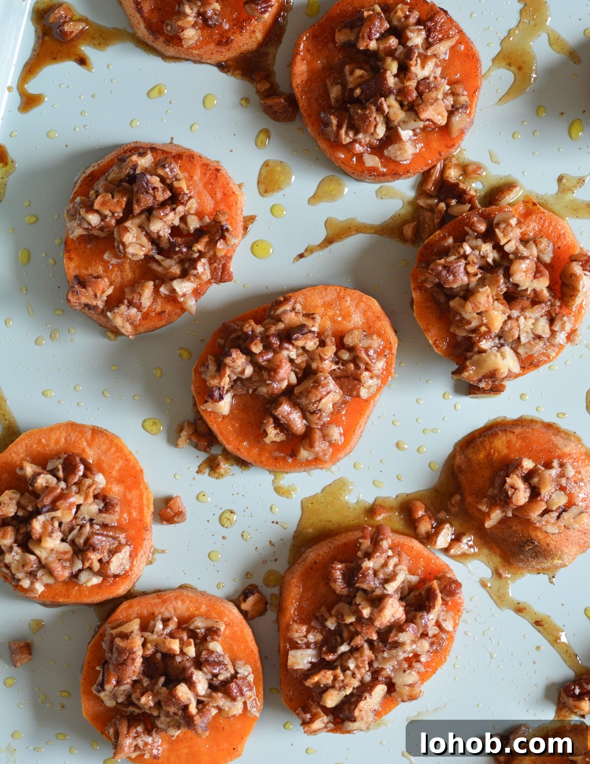 Roasted Sweet Potato Slices with Maple Candied Pecans 10 roasted sweet potatoes with pecans on top.