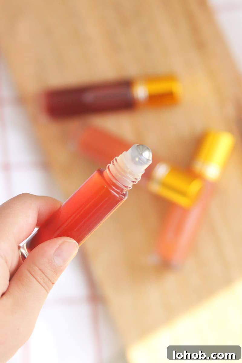 DIY Lip Gloss Without Wax: Step-by-Step Recipe for Glossy Shine 2 a pink lip gloss in a roller ball bottle with several bottles in the background