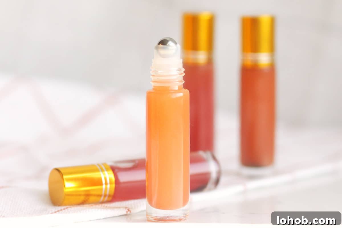 DIY Lip Gloss Without Wax: Step-by-Step Recipe for Glossy Shine 4 a pink lip gloss in a roller ball bottle with several bottles in the background