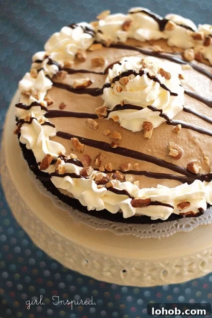 How to Make a Classic Mud Pie Dessert быстро 2 mud pie with whipped cream border and chocolate drizzle/toasted almonds on top, sitting on doily and cream cake stand on blue polka dot tablecloth