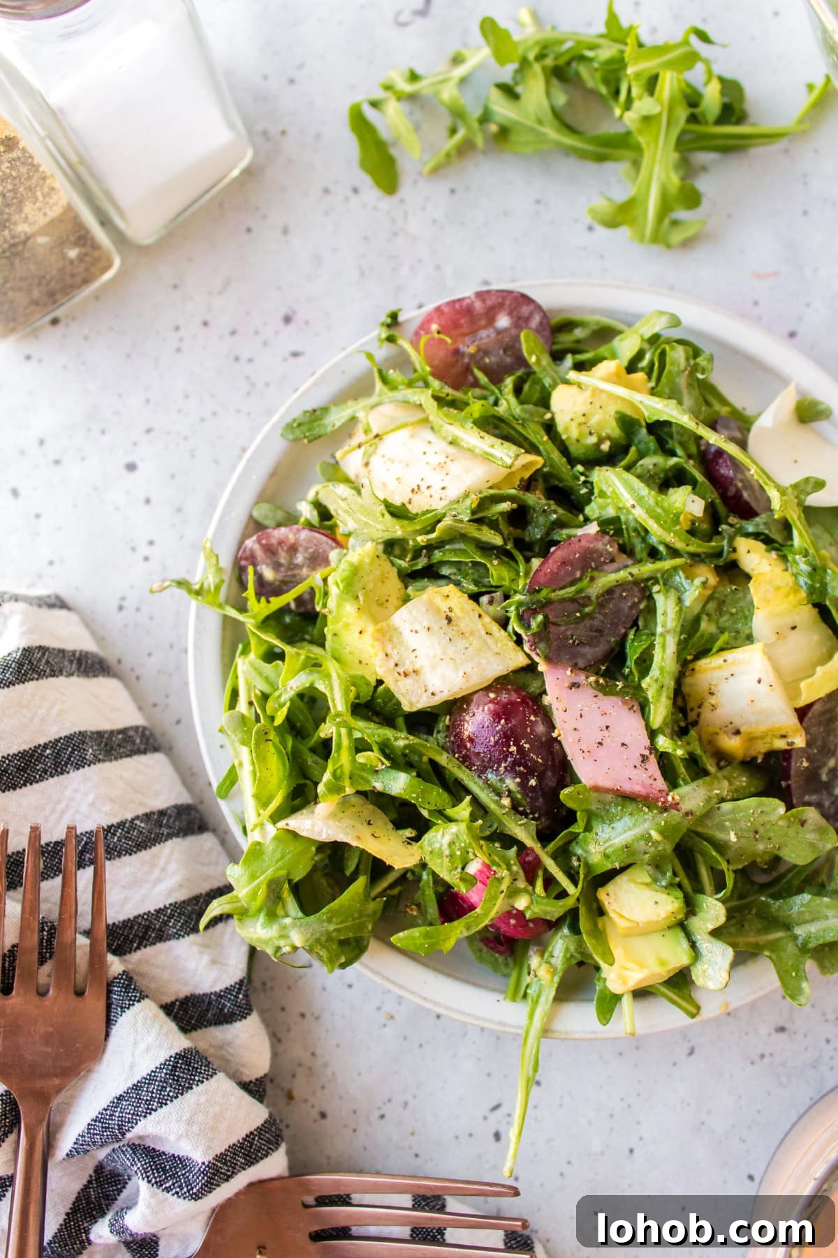 plate of grape avocado and arugula salad