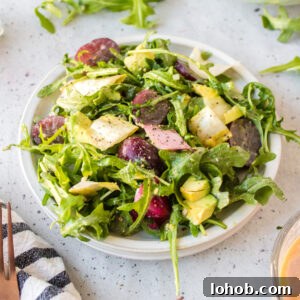 plate of grape avocado and arugula salad