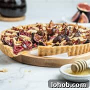 French fresh fig tart on a serving board lined with parchment paper.