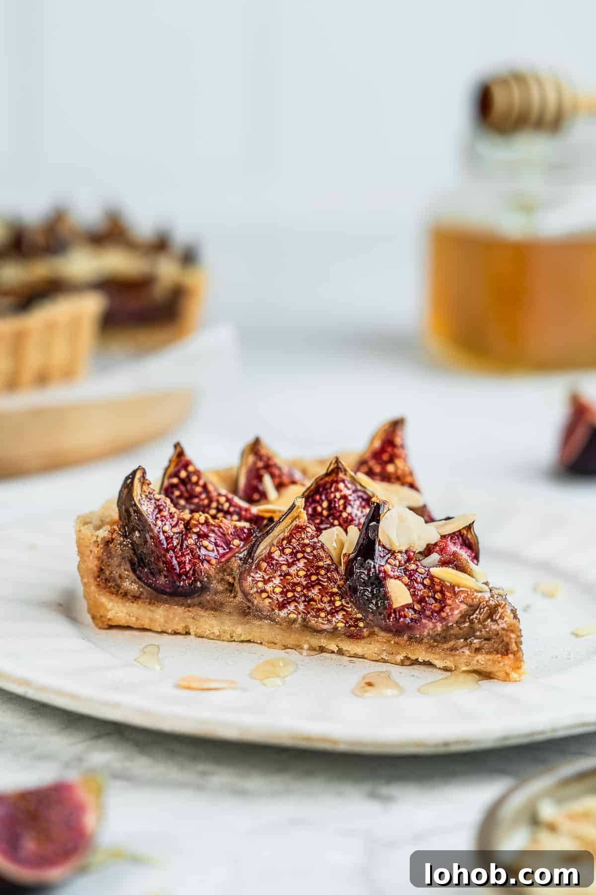 A single slice of fresh fig tart on a dessert plate.