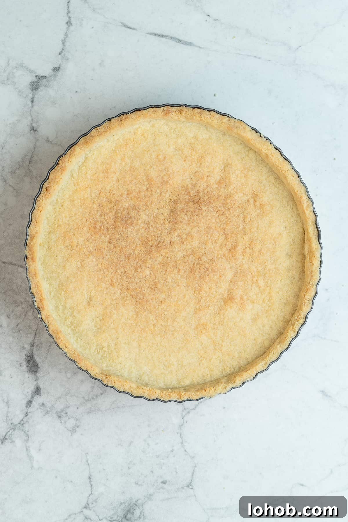 Baked tart shell in a baking mold.