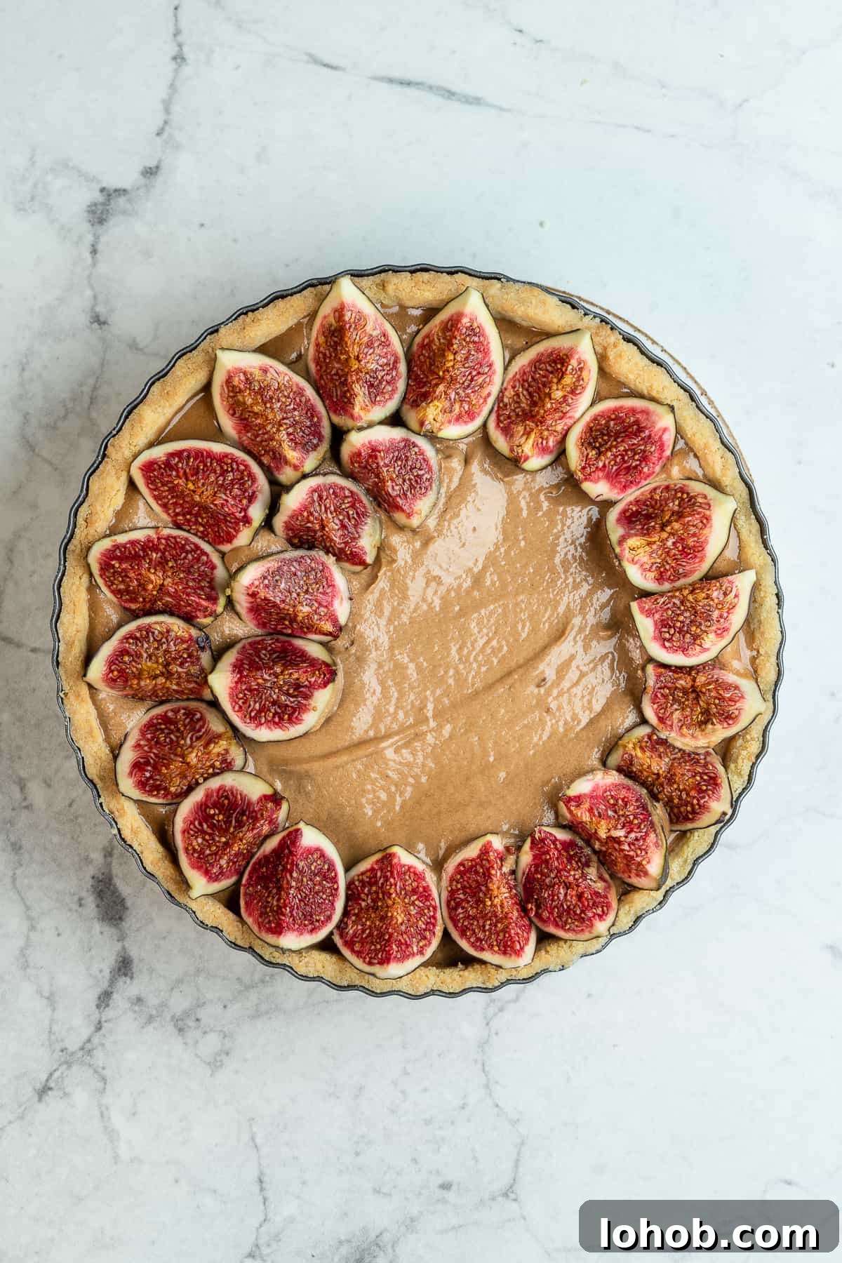 Fig slices on top of the praline cream in a baking pan.