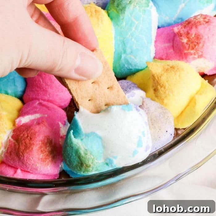 Peep S’mores Dip for Easter: Gooey Marshmallow Dessert Dip 5 graham cracker dipping into a melted Peep dip