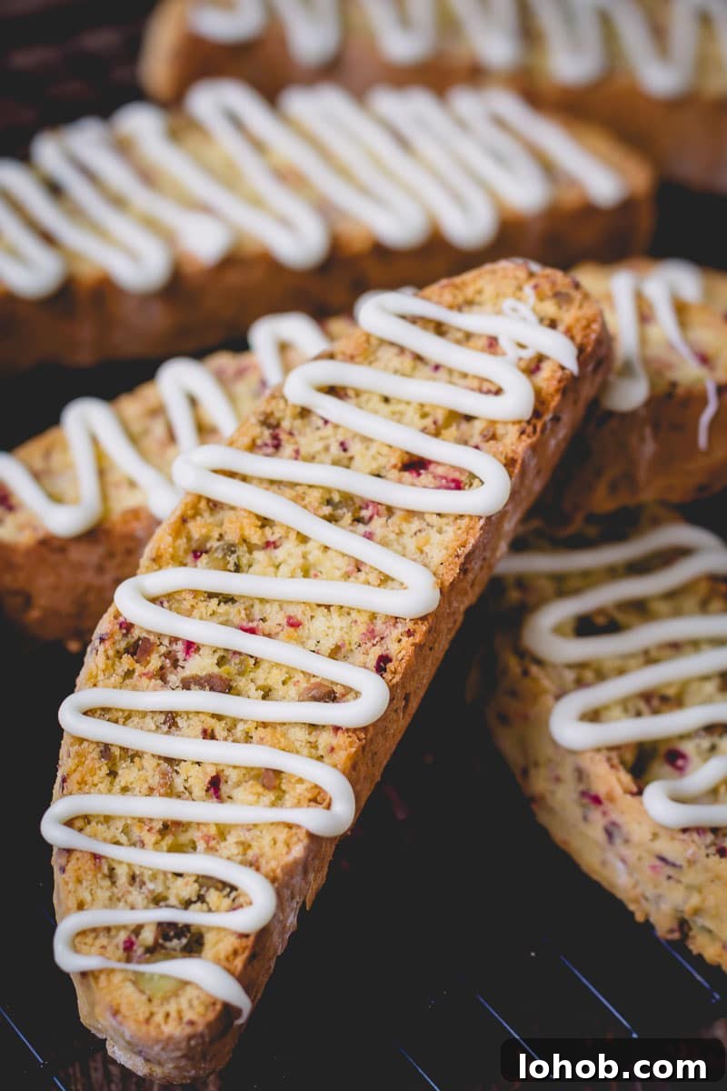 Cranberry Pistachio Biscotti Recipe — Crunchy Italian Cookie Guide 4 Cranberry pistachio biscotti topped with a white chocolate drizzle.