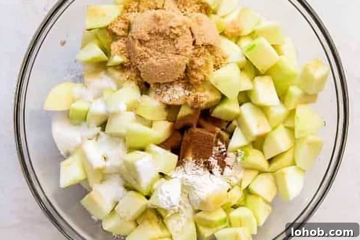 chopped apples and spices in a glass bowl.