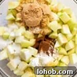 chopped apples and spices in a glass bowl.