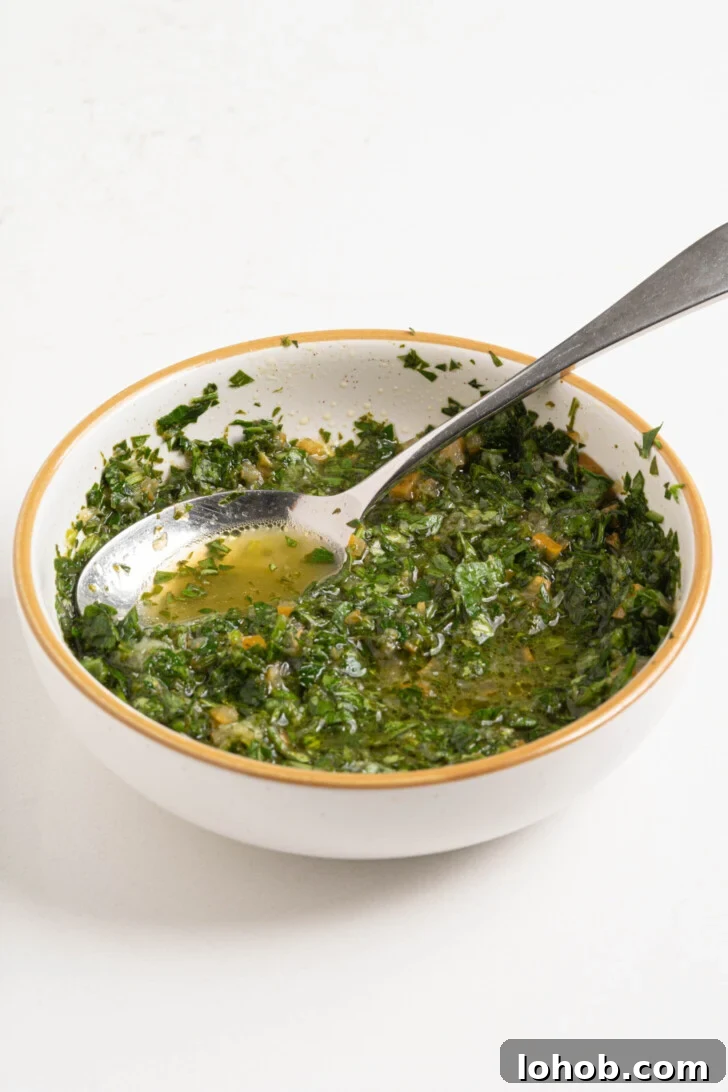 A bowl of herbs with lemon juice and oil.