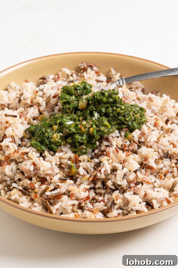 A bowl of wild rice with herbs and lemon.