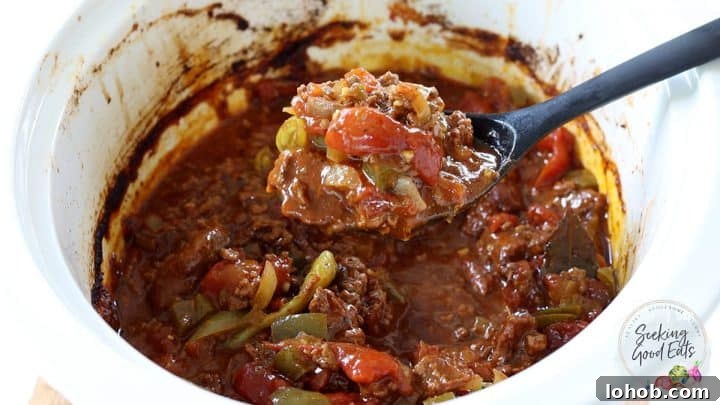 Texas-Style Crock Pot Chili Recipe (No Beans) 6 Serving a spoon full of chili out of the slow cooker