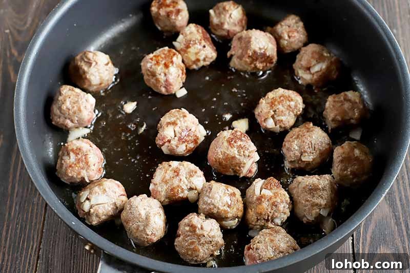 Sweet and Tangy Classic Meatballs Recipe for Weeknight Dinners 10 Horizontal image of a pan with browning meatballs.