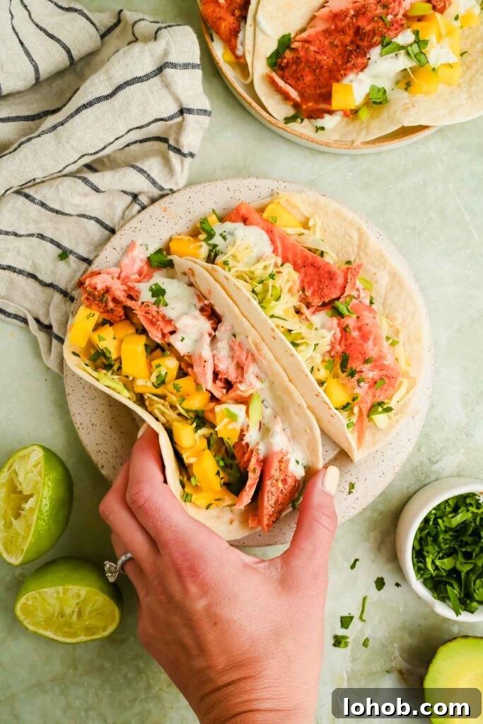 two trout tacos topped with mango slaw served on speckled plate.