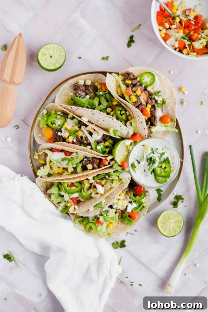 Plate of Carne Asada Street Tacos with a small bowl of coconut lime crema.