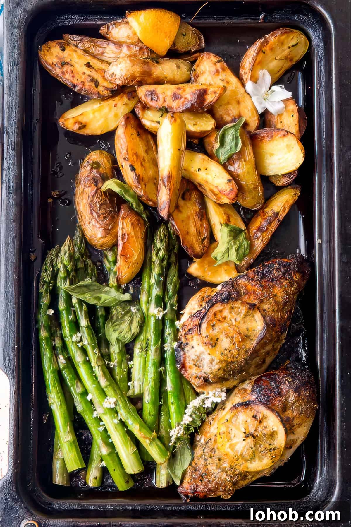Sheet pan chicken and potatoes with lemon and herbs.