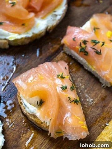 Lox on top of mascarpone toast on a cutting board with an old school butter knife covered in mascarpone.