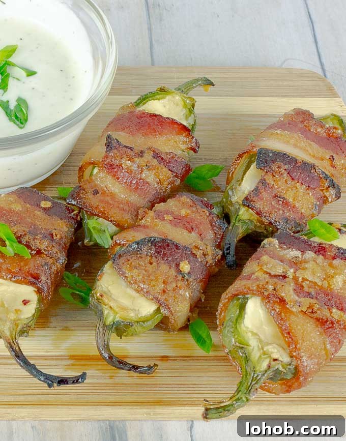 Bourbon-Candied Bacon Jalapeño Poppers Wrapped in Bacon 2 five Bourbon Candied Bacon Wrapped Jalapeno Poppers on wood with ranch