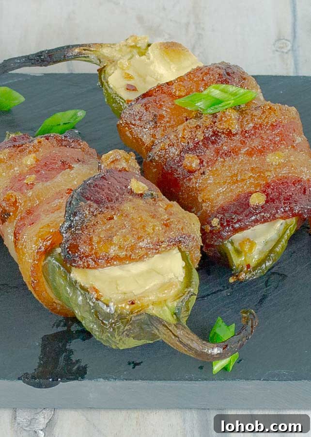 Bourbon-Candied Bacon Jalapeño Poppers Wrapped in Bacon 5 two Bourbon Candied Bacon Wrapped Jalapeno Poppers on black slate