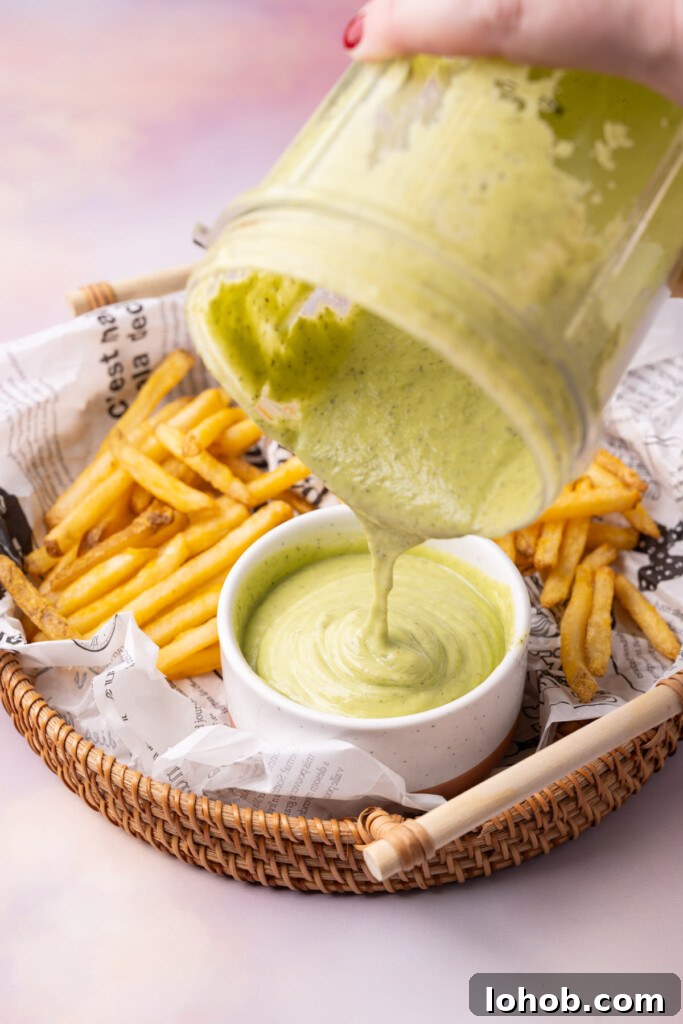 Pouring green ranch dressing into a ramekin. 