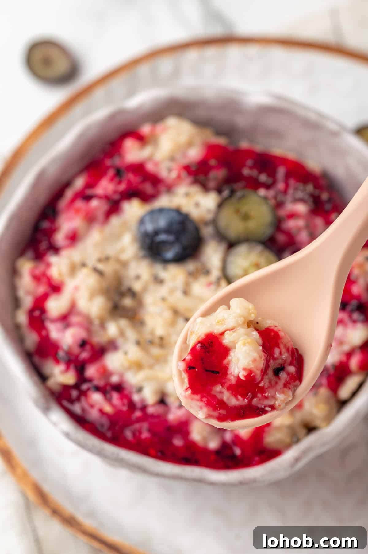 Homemade baby oatmeal is a great beginning food for infants transitioning to solid foods. Nutrient-dense, easy to digest, and simple to make! Spoonful of baby oatmeal with jam