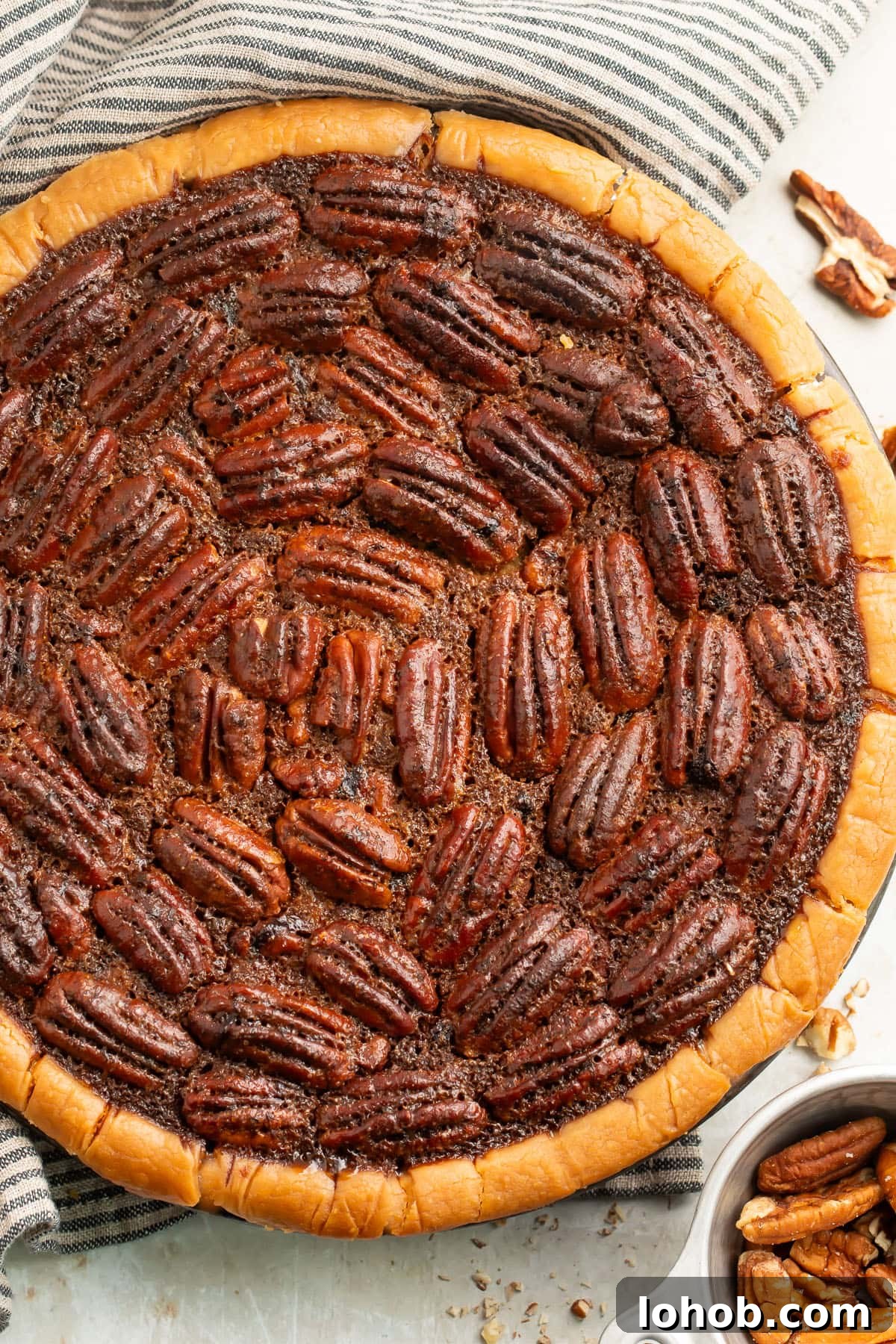 Pecan Pie Without Gluten: Classic Recipe for a Flaky Crust 3 Top down view of a whole gluten free pecan pie in a pie plate on a neutral table.
