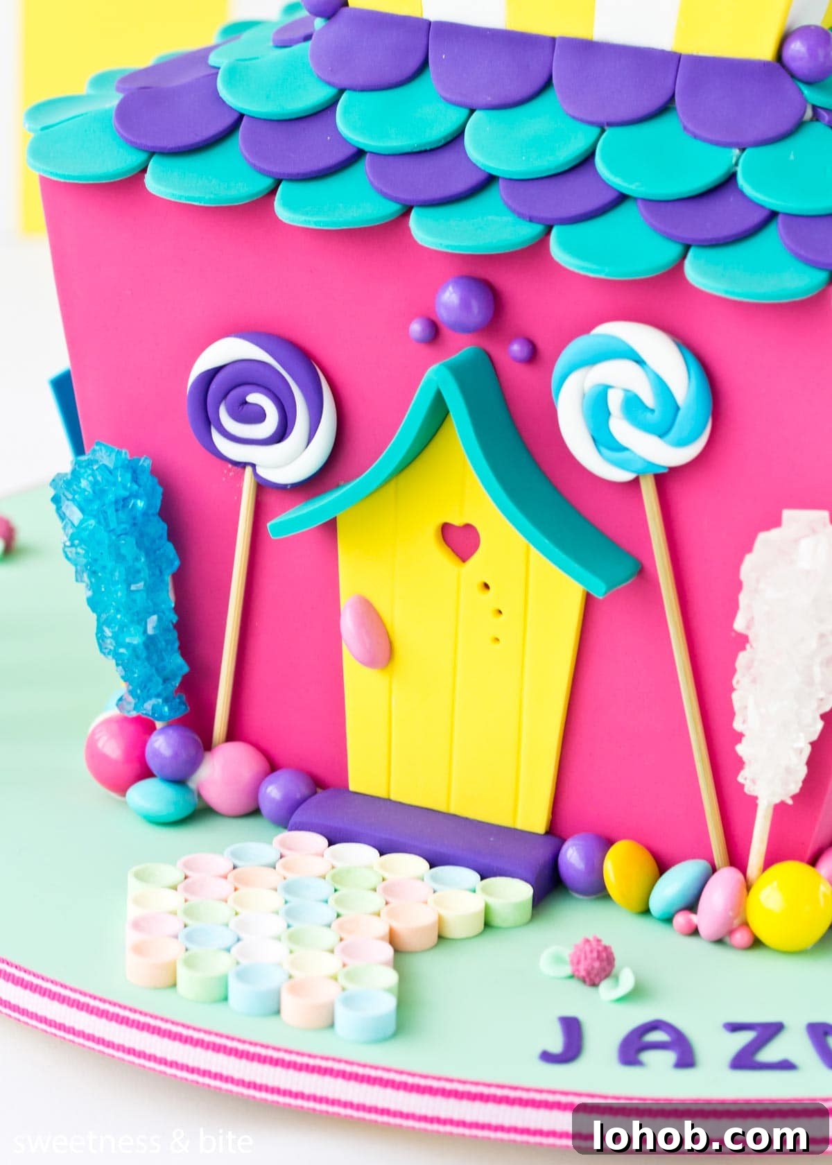 How to Adhere Fondant to Fondant: Guide to Edible Glue 7 Close up of a candy house cake with a border of assorted lollies attached with royal icing around the bottom of the cake