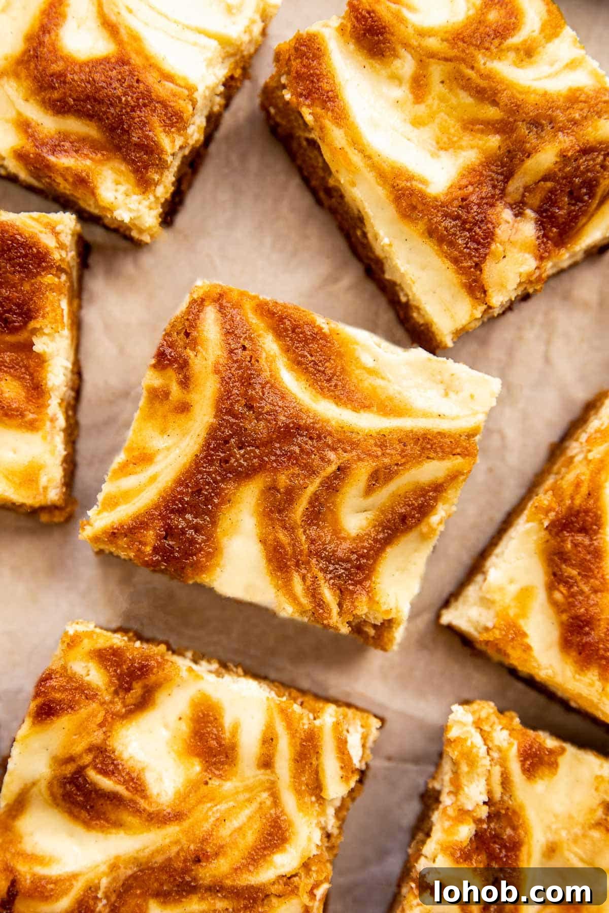 a carrot cake cheesecake bar cut into squares on parchment paper. 