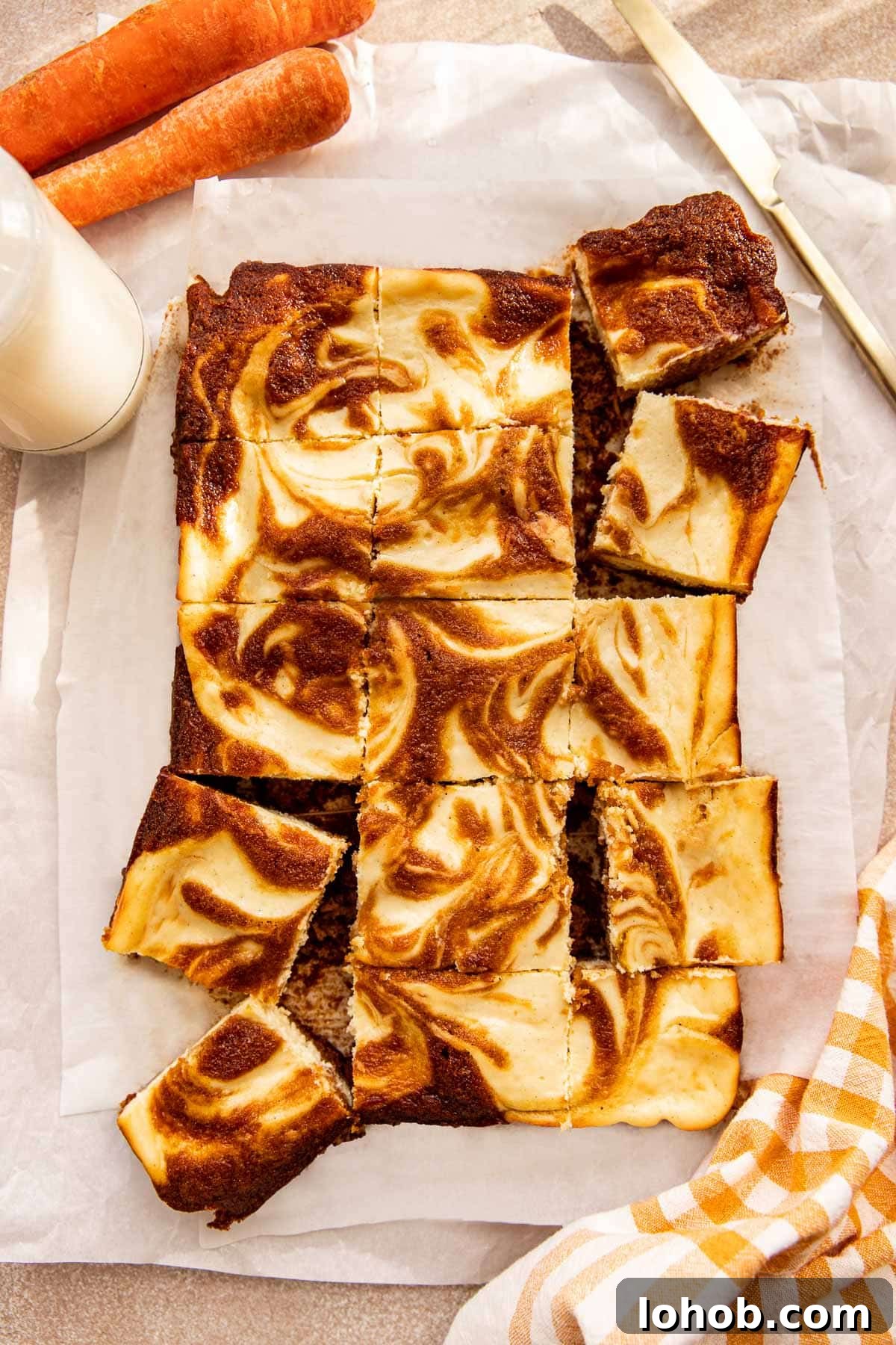 carrot cake bars cut into squares on parchment paper. 