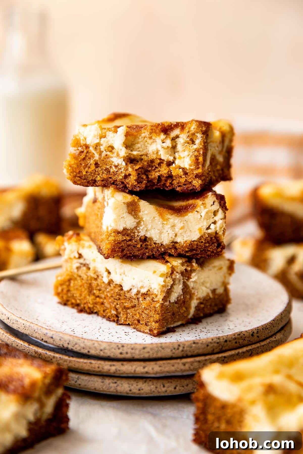 stacked carrot cake cheesecake bars on a plate. 