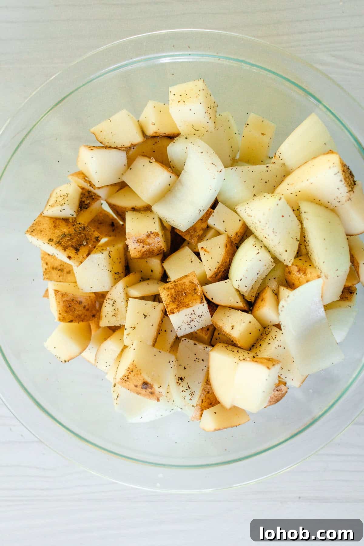 Dice the potatoes and onions and toss them in a small bowl with avocado oil, salt, and pepper.